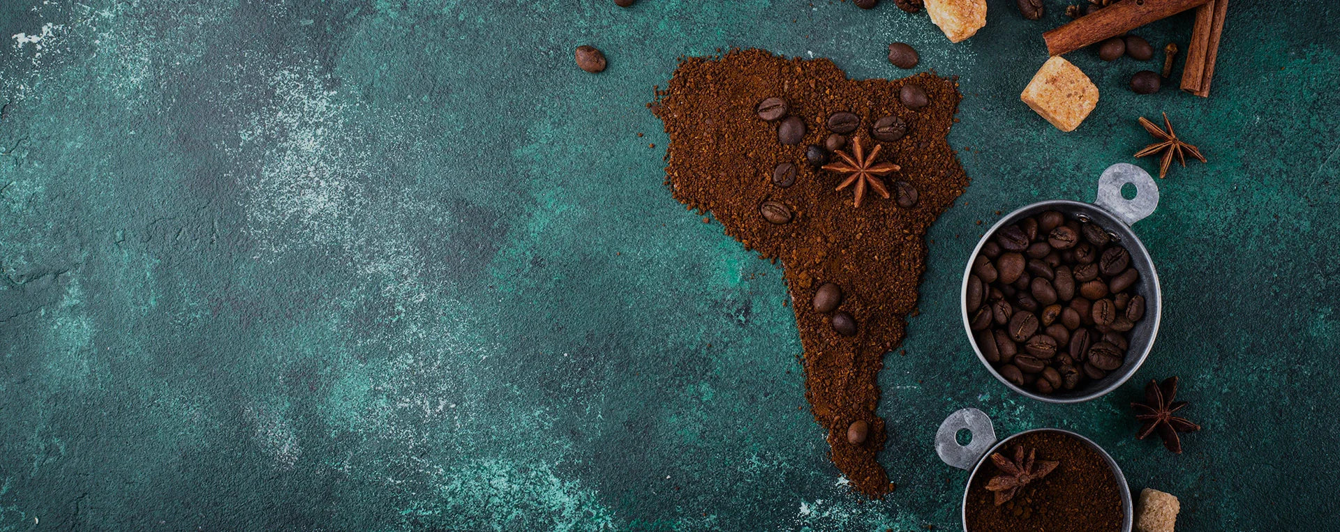 Map of South America made of coffee grounds and beans, surrounded by spices on a textured background.